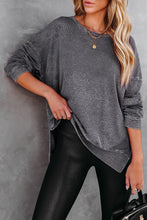 model wearing side slit sweatshirt with leather leggings holding a black handbag